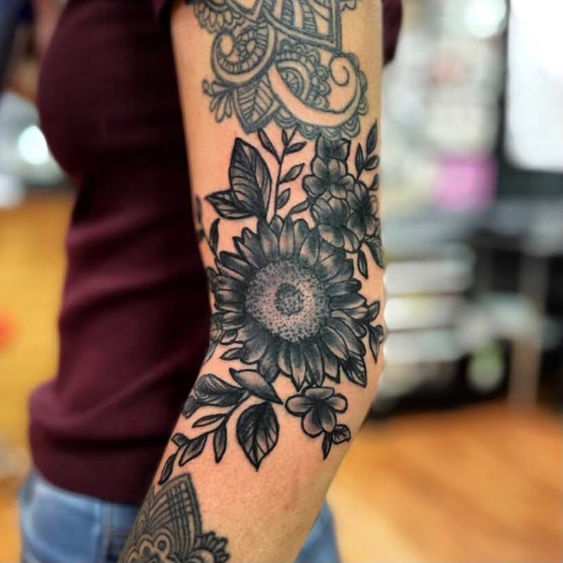 Dark sunflower tattoo on outside forearm by Tattoo Artist, Nick Young in Kansas City 
